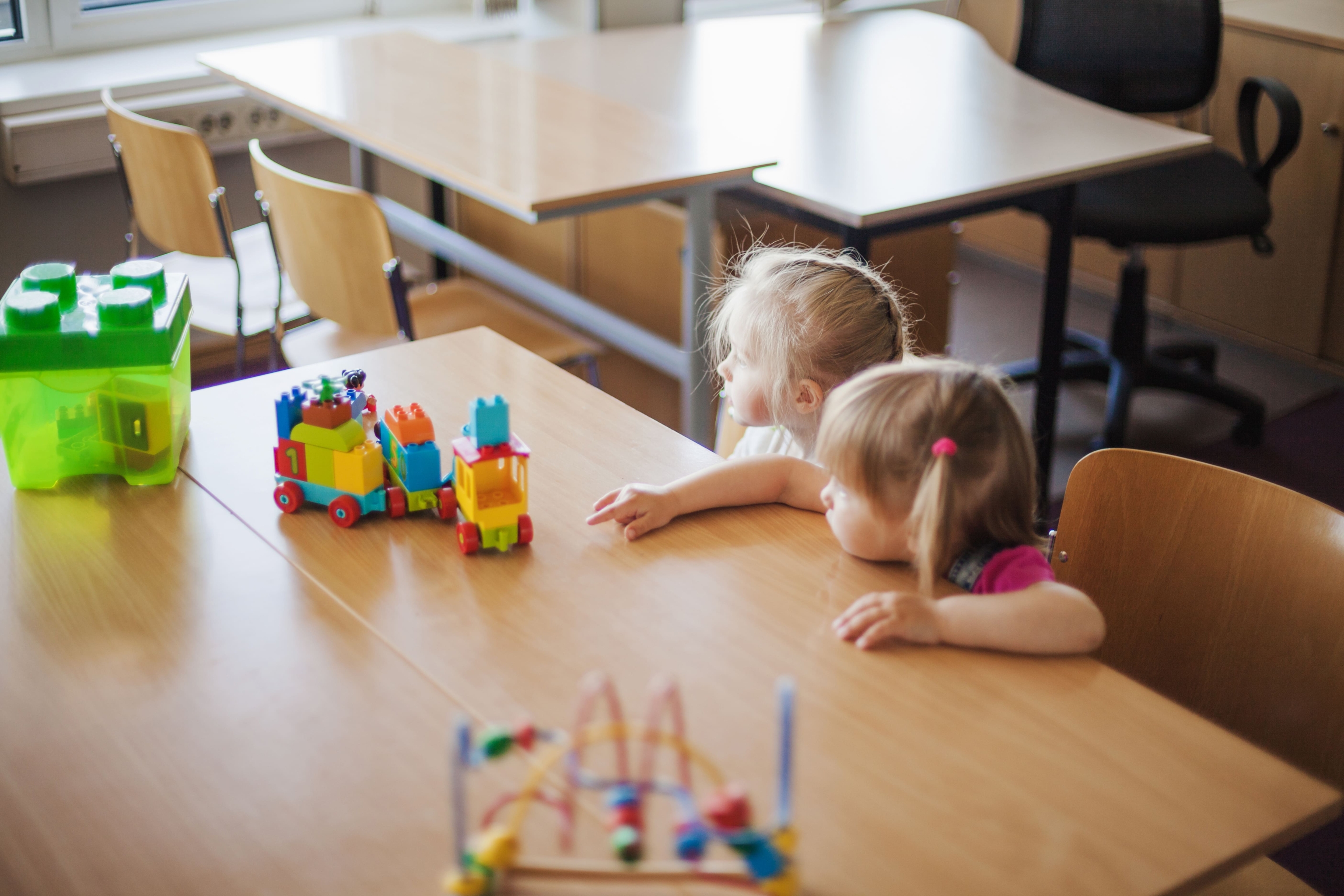 malen-kie-devocki-sidat-za-stolom-s-igruskami (1).jpg